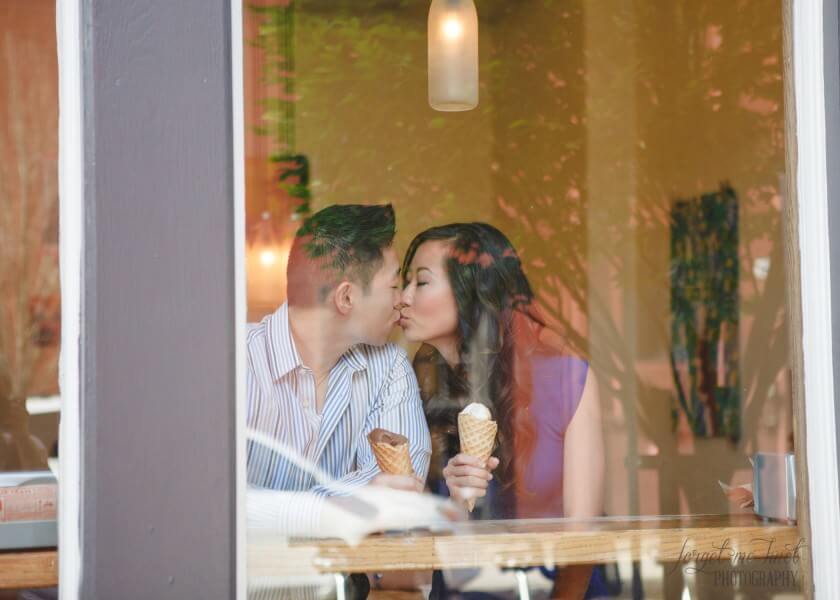 engaged couple kissing while having ice cream at Jeni's