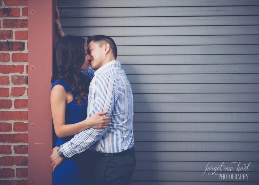 engaged couple kissing in front of garage metal doors