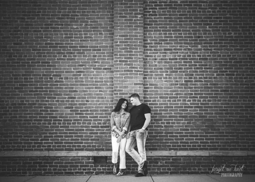 wide black and white photo of couple leaning on brick in westerville ohio