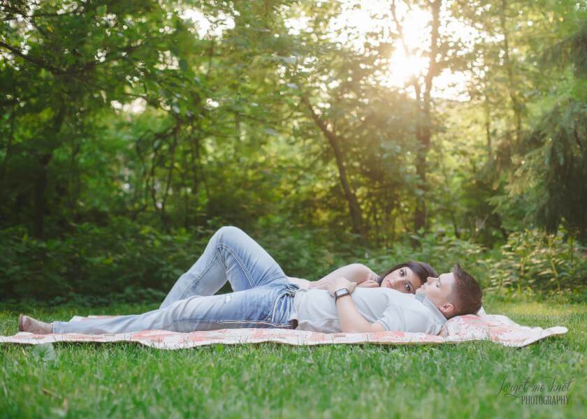 engaged couple laying in grass at Inniswood