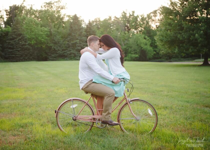 Vintage Engagement Photography of couple facing each oher on bike