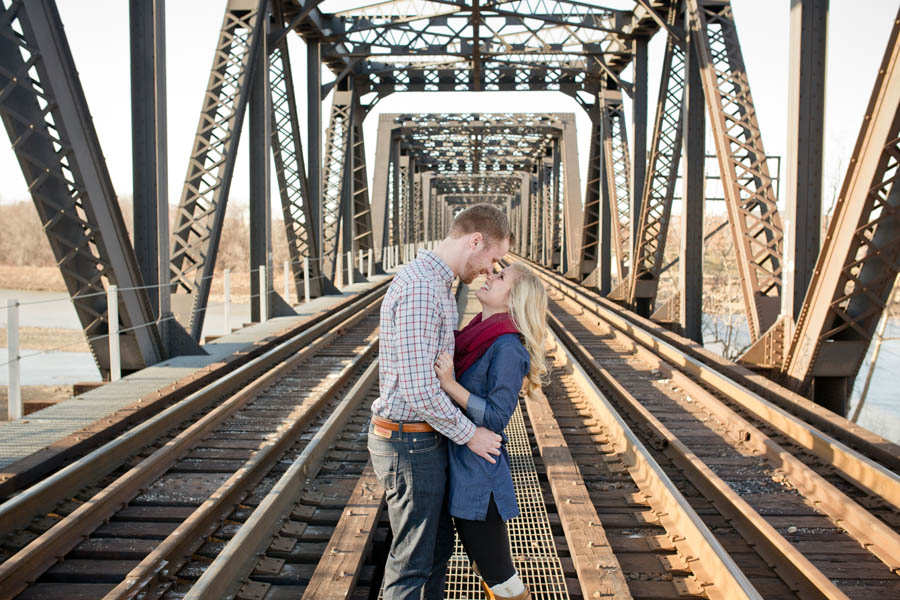 engagement photo of couple on bridge laughing
