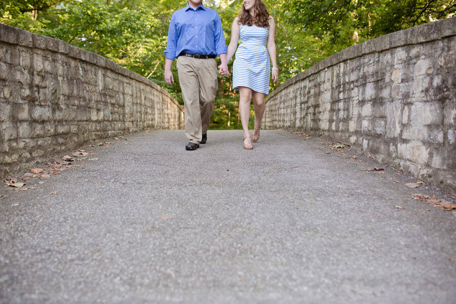 photo of engaged couple holding hands walking
