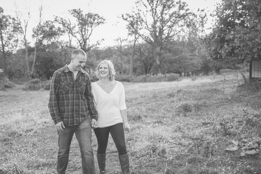 engaged couple laughing and walking at columbus farm