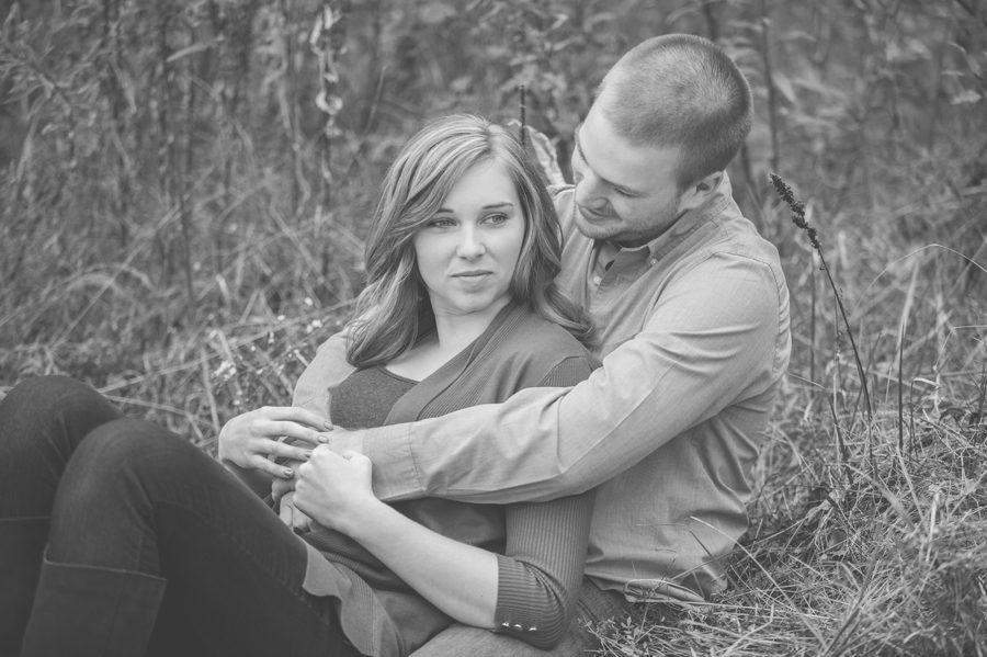 engaged couple laying in grass at Highbanks Metro Park