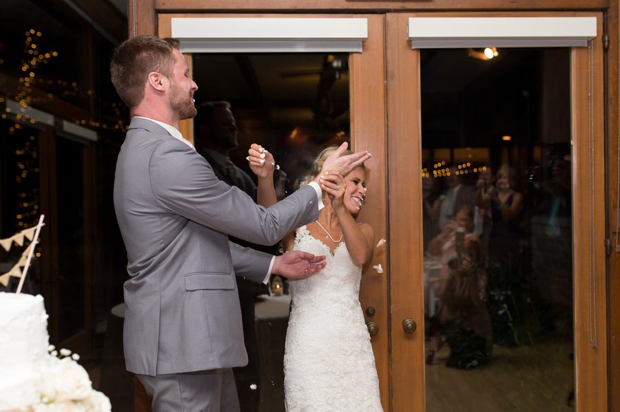 groom smashing cake in brides face