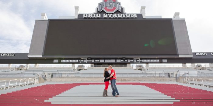 engaged couple kissing at Ohio State University stadium