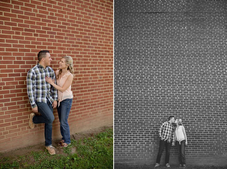 engaged couple kissing with brick wall