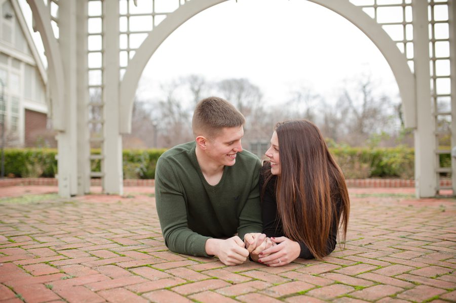 engaged couple laying on brick at Franklin Park Conservatory