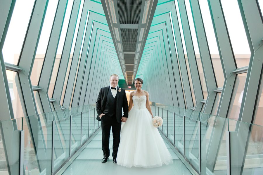 married couple smiling looking at camera on skybridge