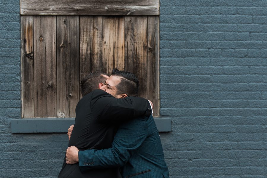 same sex couple hugging after first look