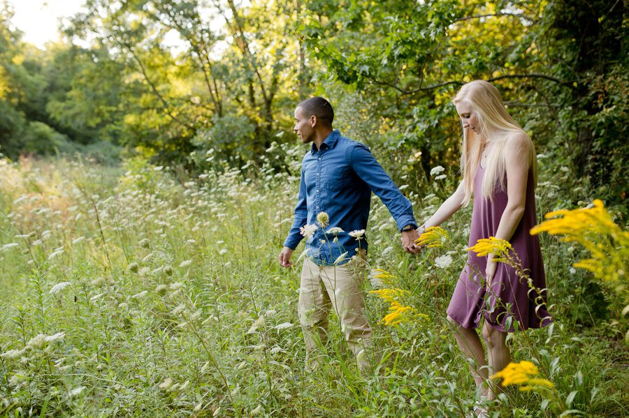 engaged couple walking through field at Slate Run Farm