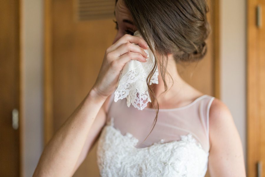 bride wiping tears with heirloom handkerchief