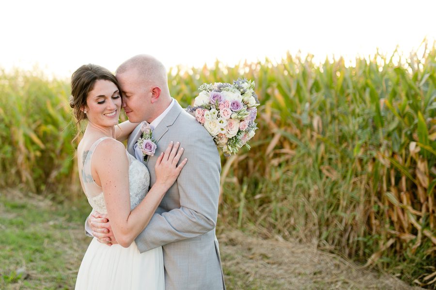 bride and groom by corn field at Rustic Barn Wedding