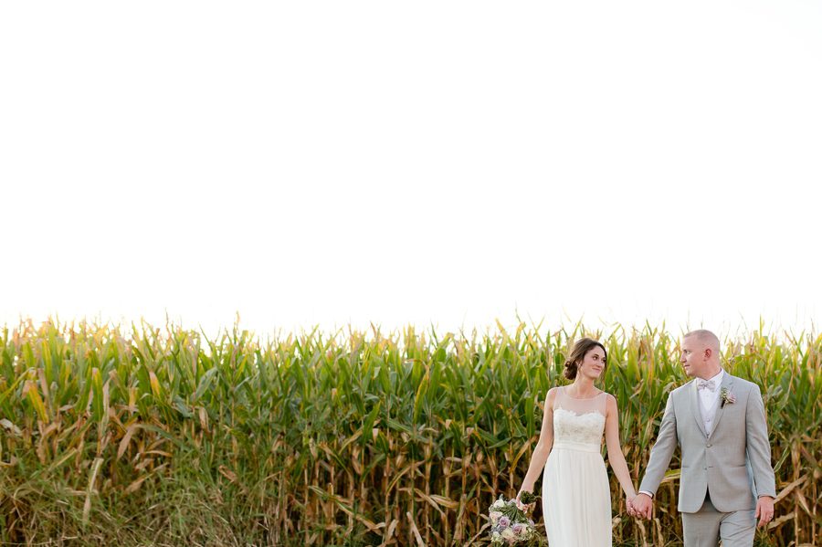 married couple walking holding hands near field