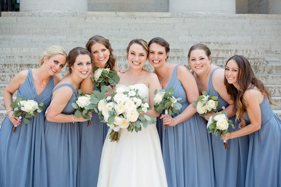 bride and bridesmaids huddled together at statehouse wedding