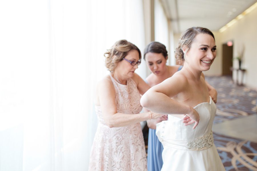 mother of bride helping bride get dressed at ohio statehouse