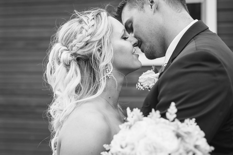 black and white photo of married couple going in for a kiss