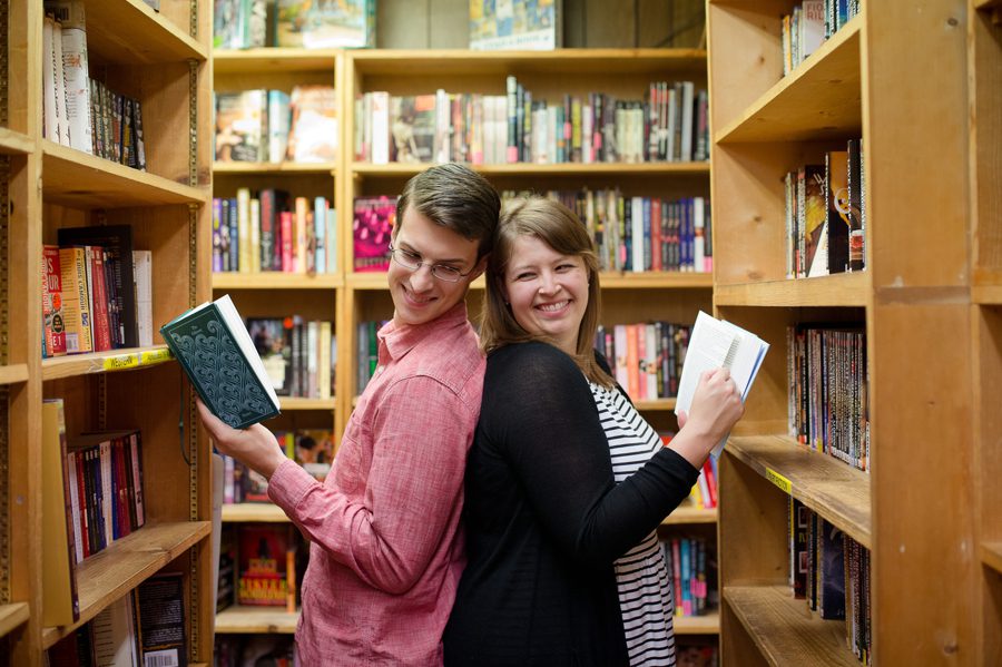 engaged couple reading books back to back 