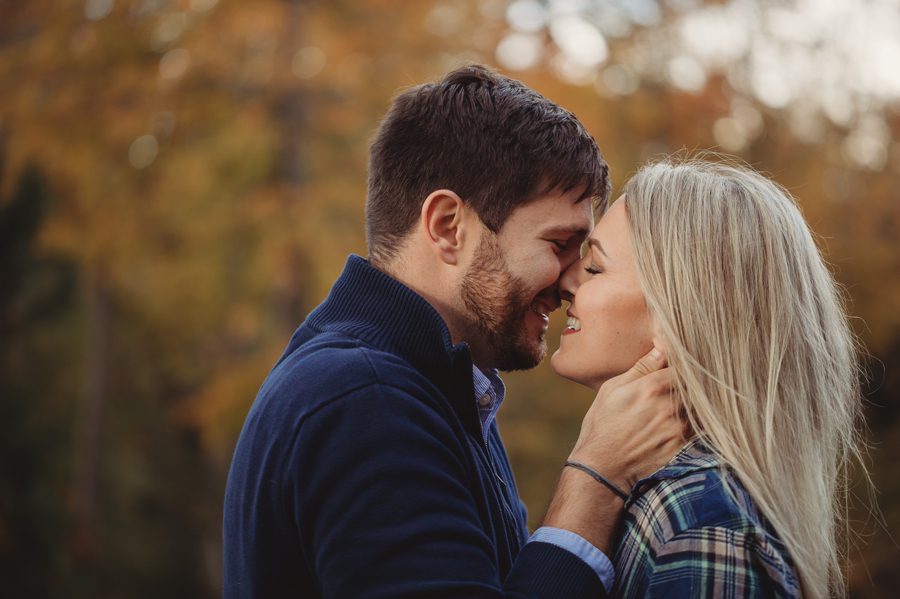 engaged couple laughing while kissing