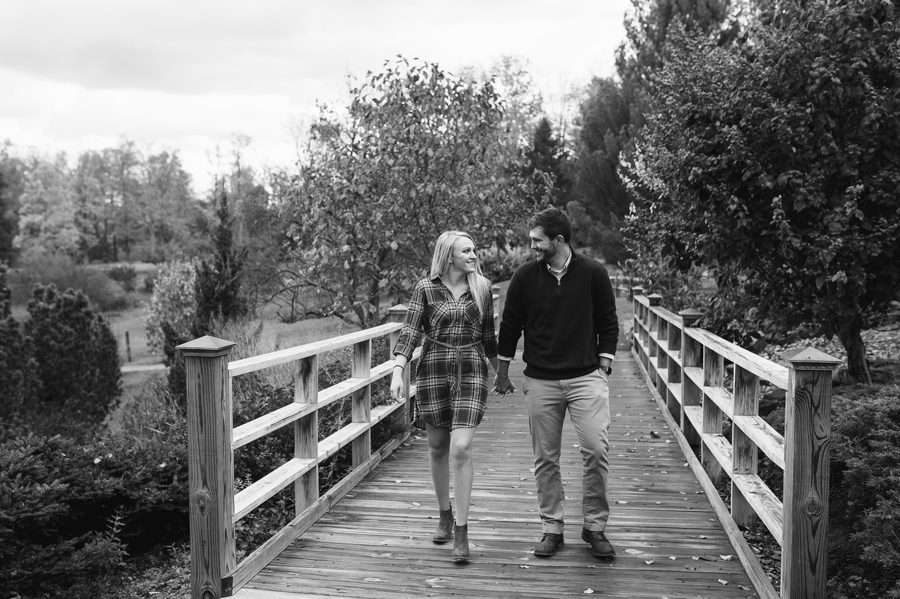 black and white photo of engaged couple walking at Dawes Arboretum