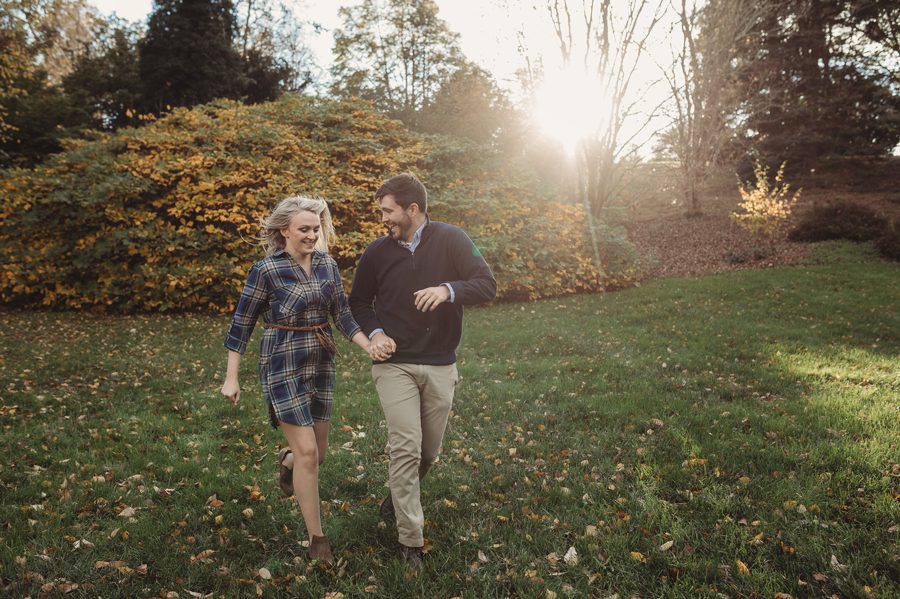engaged couple running at Dawes Arboretum Engagement