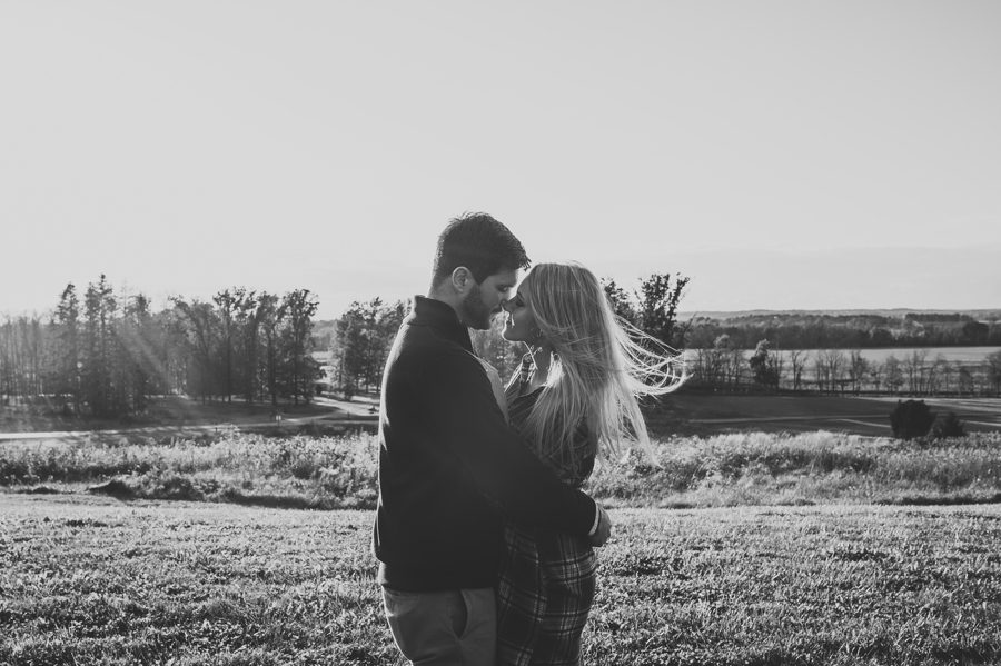 black and white photo of engaged couple in wind