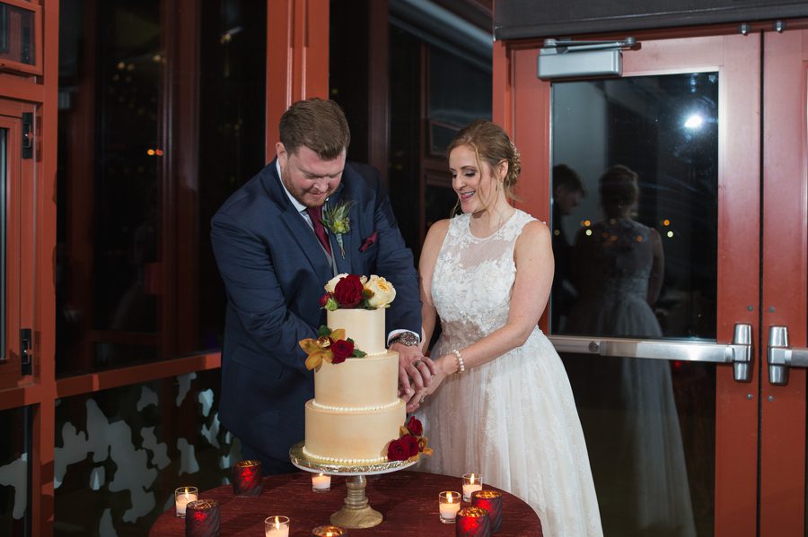 married couple cutting wedding cake at grange insurance audubon wedding