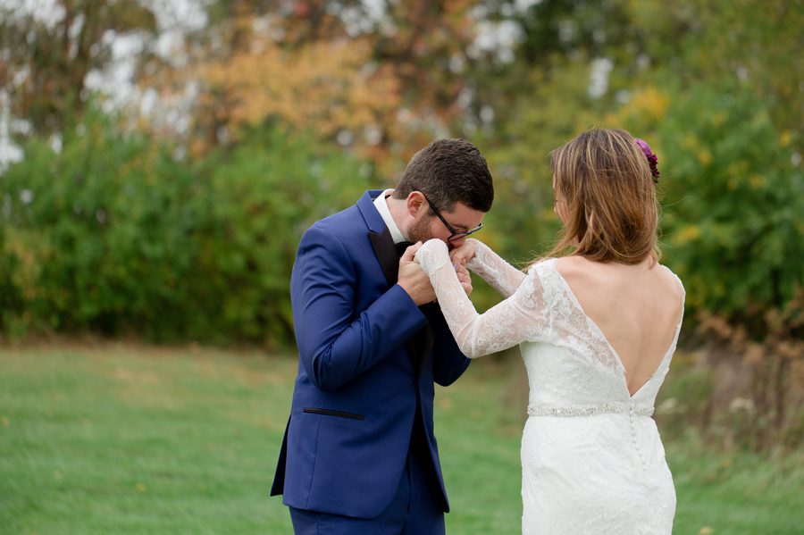 groom kissing brides hands at jorgensen farm wedding