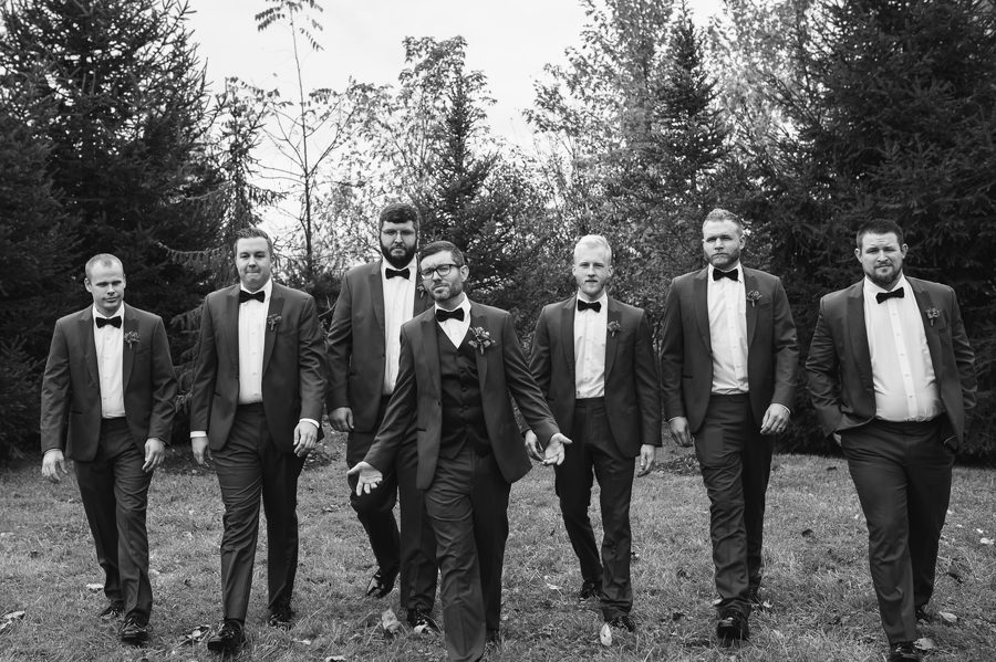 black and white photo of groomsmen walking at jorgensen farm