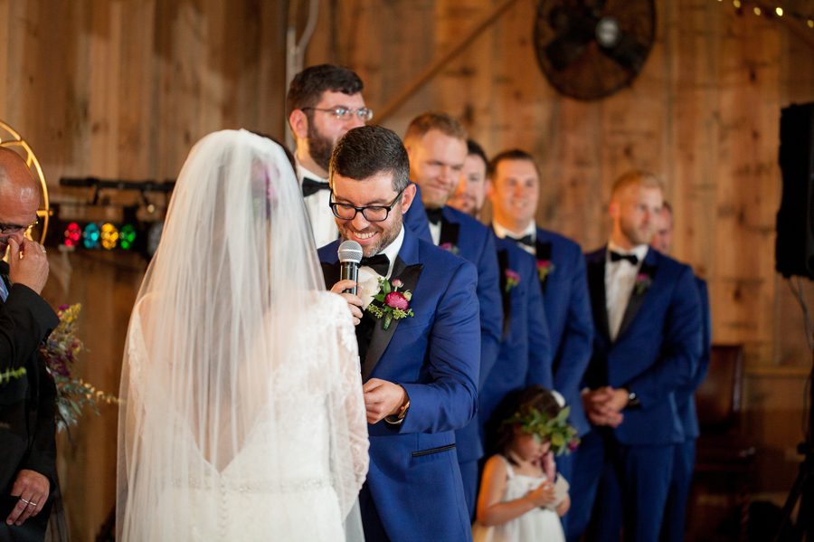 groom reading vows at wedding ceremony at jorgensen farm