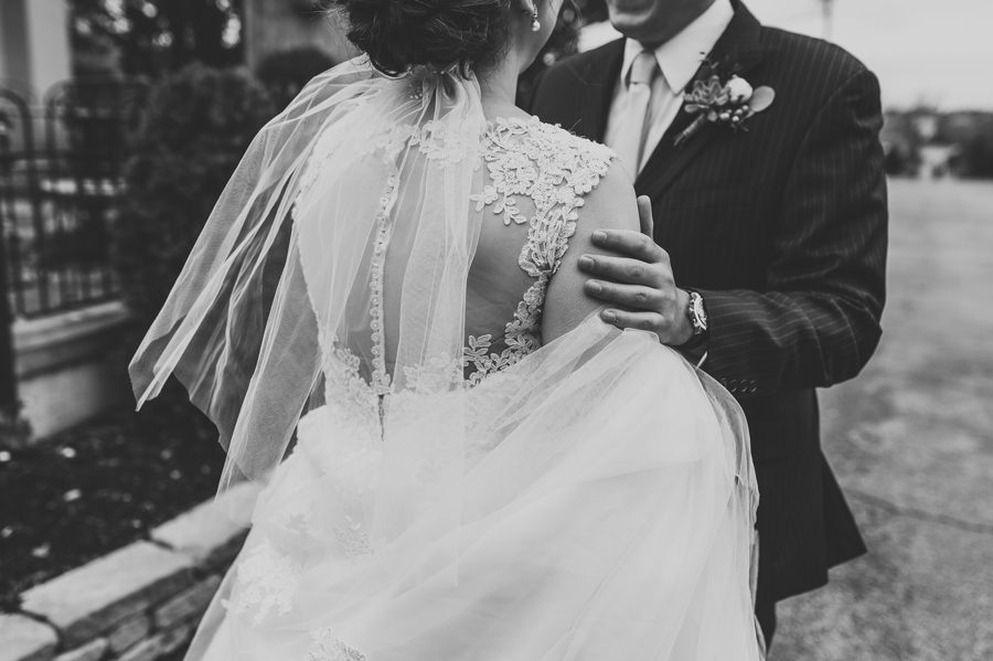 black and white photo of grooms hand on brides shoulder