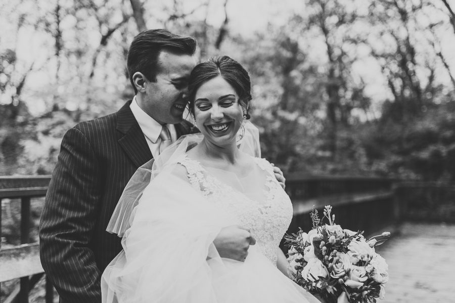 black and white photo of groom whispering in brides ear