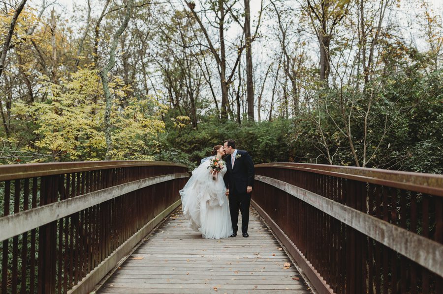 wide photo of couple kissing on bridge at la scala wedding