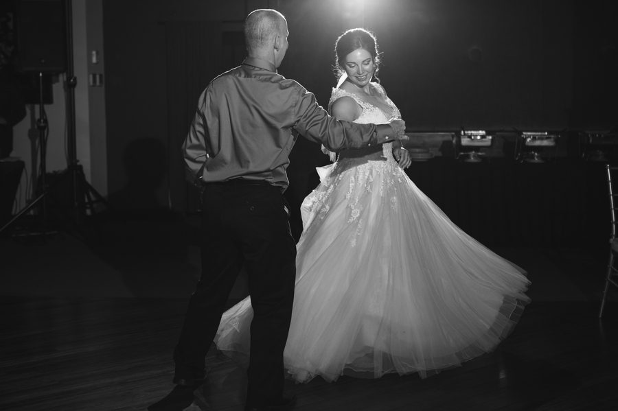 black and white photo of father twirling his daughter during dance