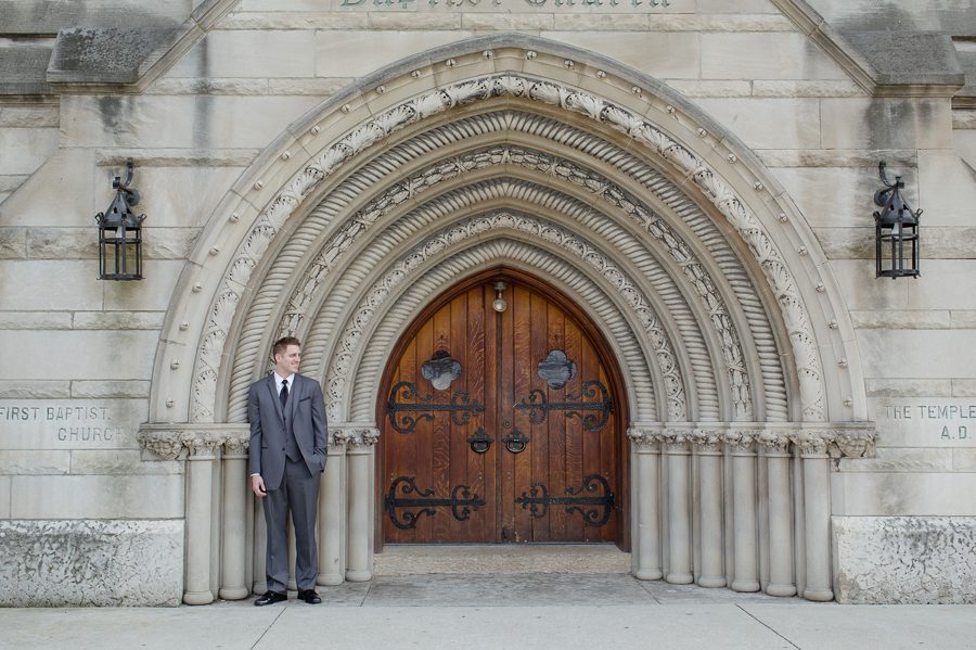 groom leaning on the bluestone arch entrance