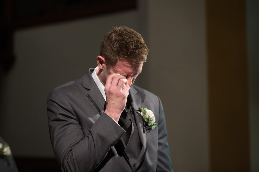emotional groom while bride walks down aisle at the bluestone