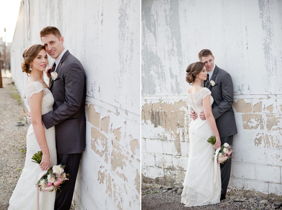 bride and groom leaning on alley wall of the bluestone