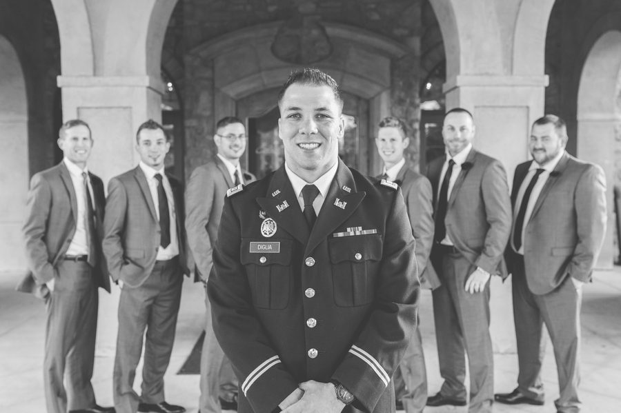 black and white photo of groom with groomsmen in background