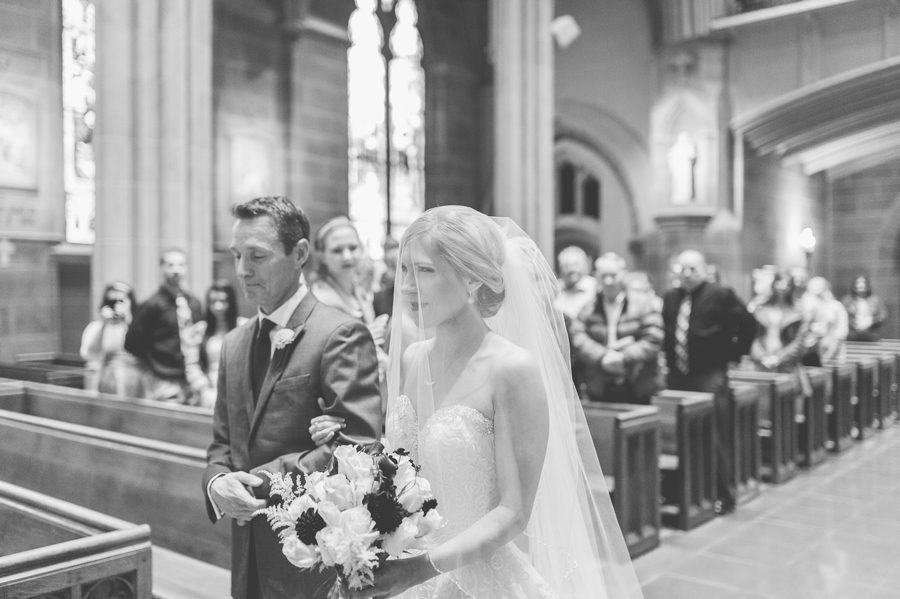 back and white photo of bride walking down aisle