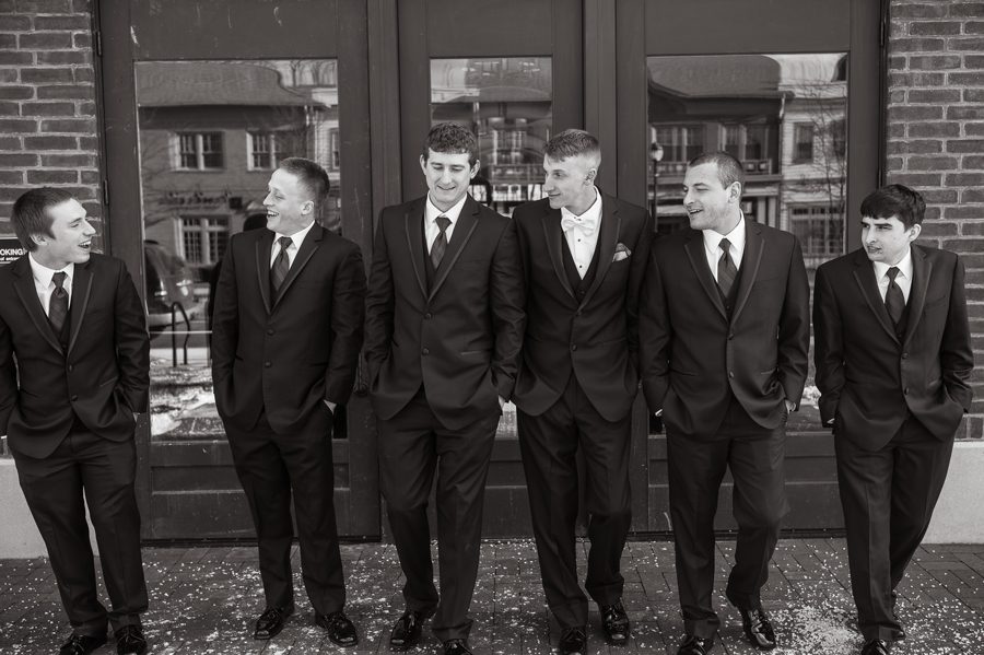 black and white photo of groom and groomsmen walking
