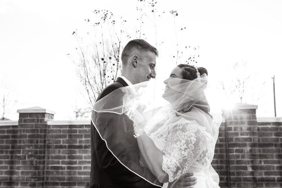 black and white photo of bride and groom laughing