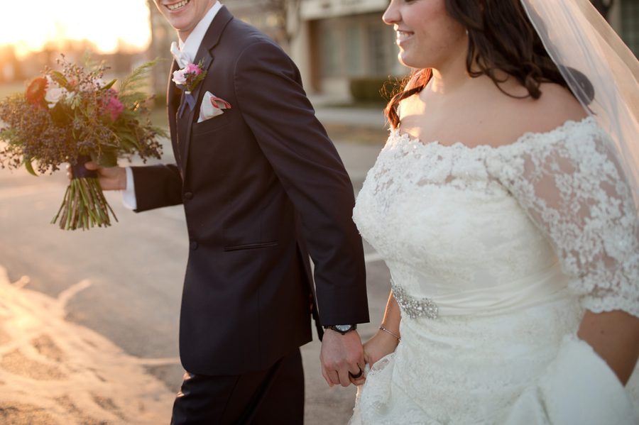 bride and groom holding hands while walking