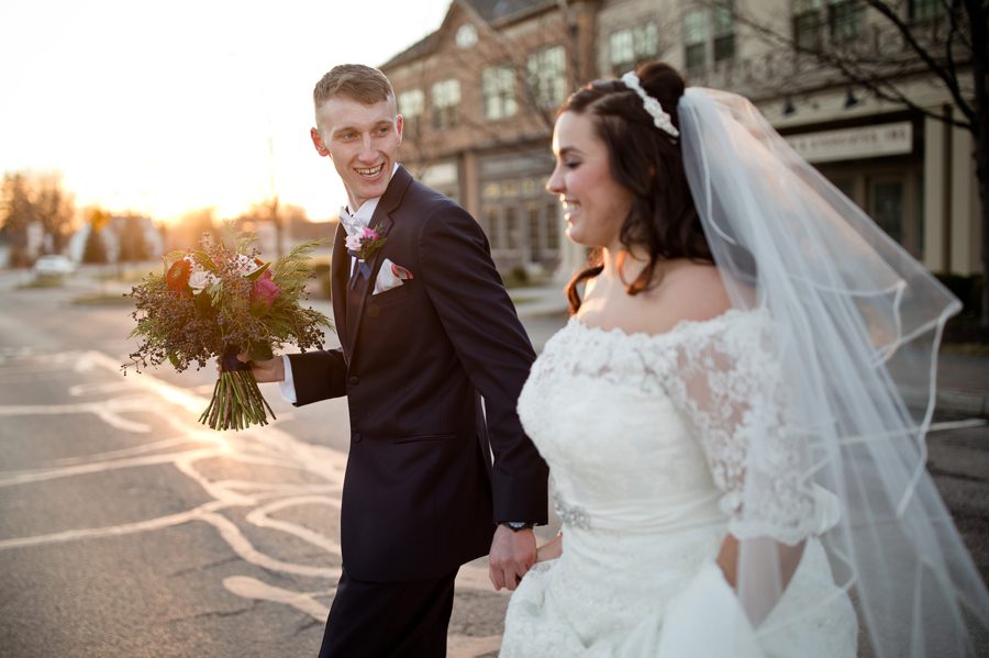 grrom smiling at bride while walking