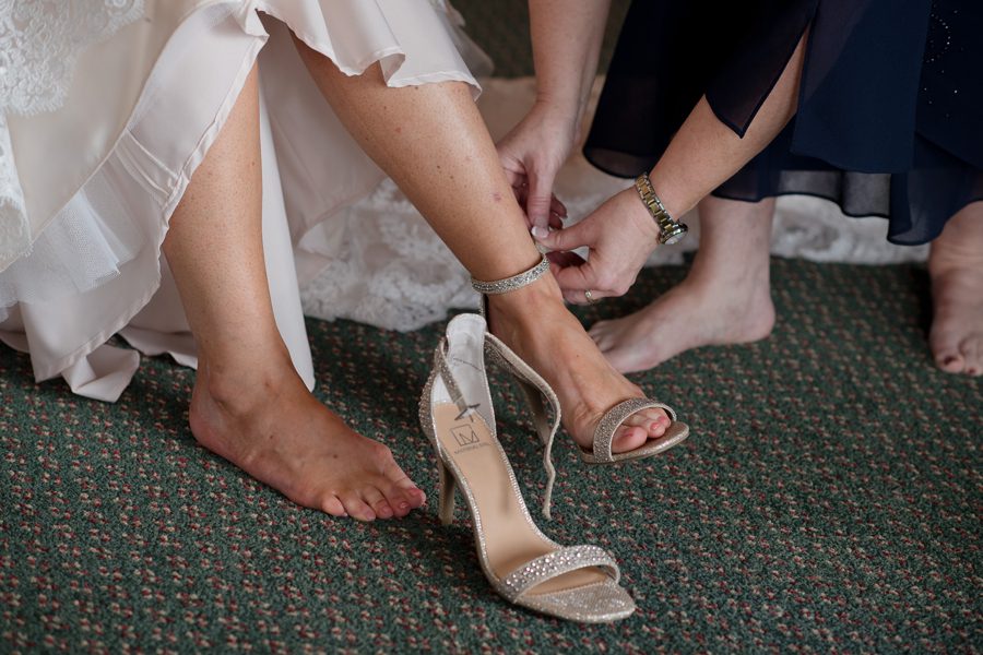 bride putting on wedding shoes