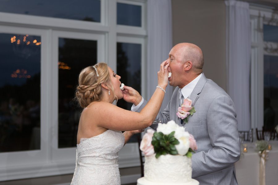 bride and groom feeding each other wedding cake