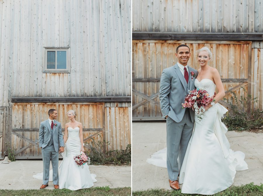 bride and groom looking at each other standing in front of a barn