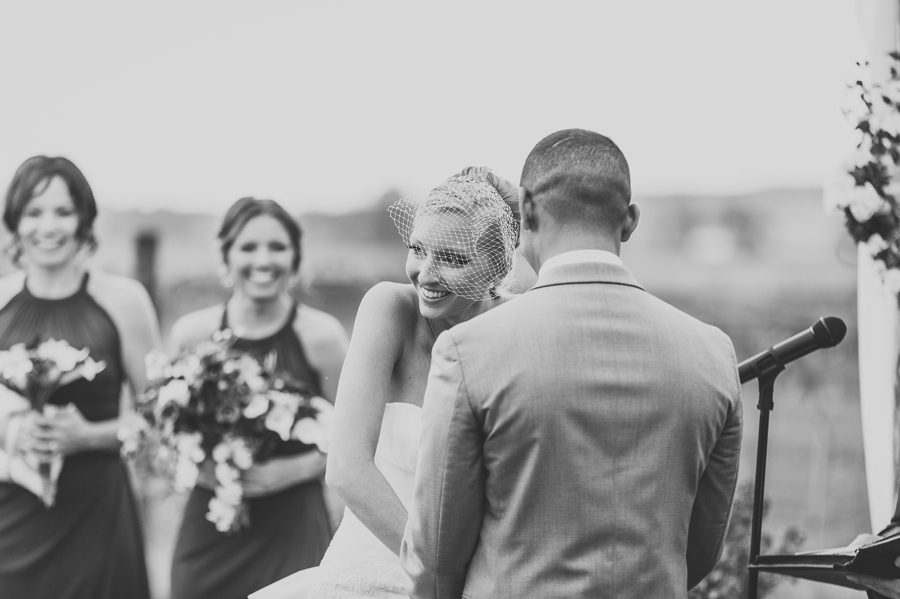 black and white photo of bride laughing during ceremony