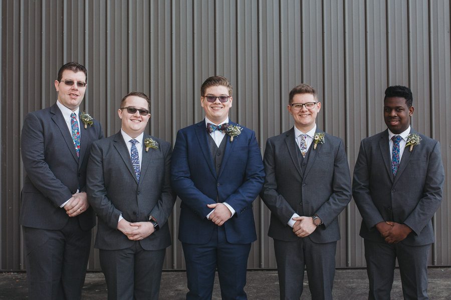 groom and groomsmen smiling at the camera
