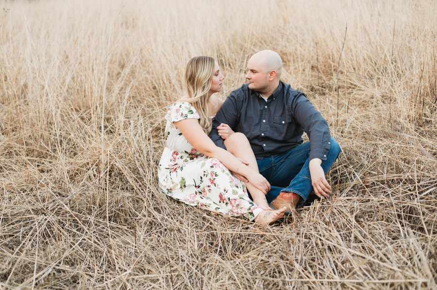 engaged couple in grassy field at gorman nature center